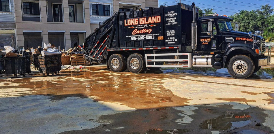 black dumpster on the middle of a patio picking up some garbage